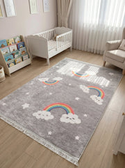 Tapis rectangulaire gris moucheté orné de nuages blancs souriants, d'arcs-en-ciel colorés et d'étoiles blanches, dans une chambre d'enfant