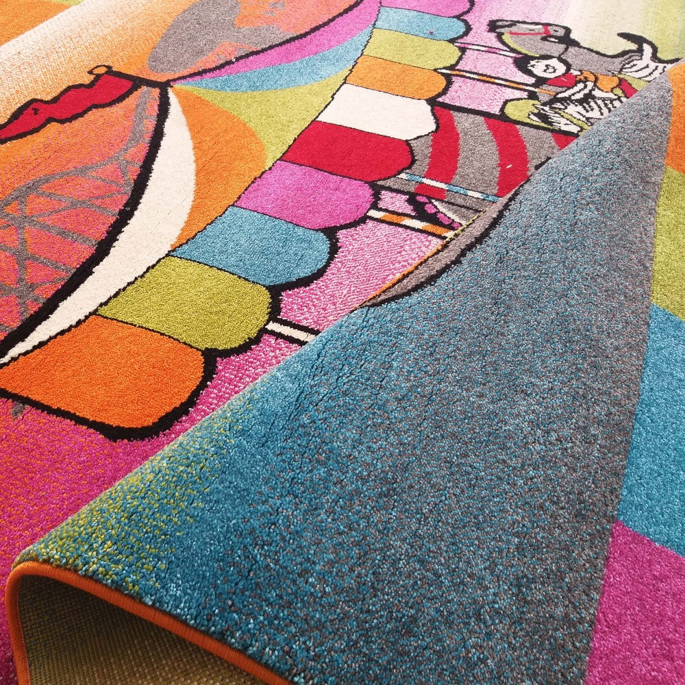 Tapis multicolore aux motifs abstraits et dessin animé, enroulé pour révéler son envers texturé bleu et gris