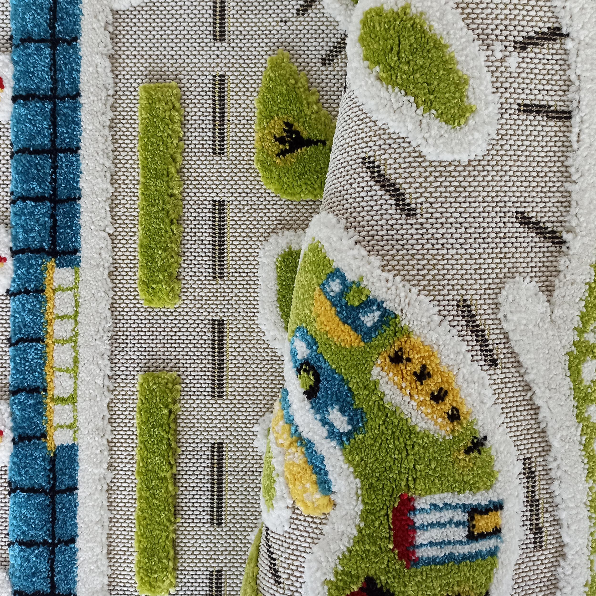 Tapis en relief avec des motifs colorés de routes, arbres et bâtiments en vert, bleu, blanc, jaune et noir
