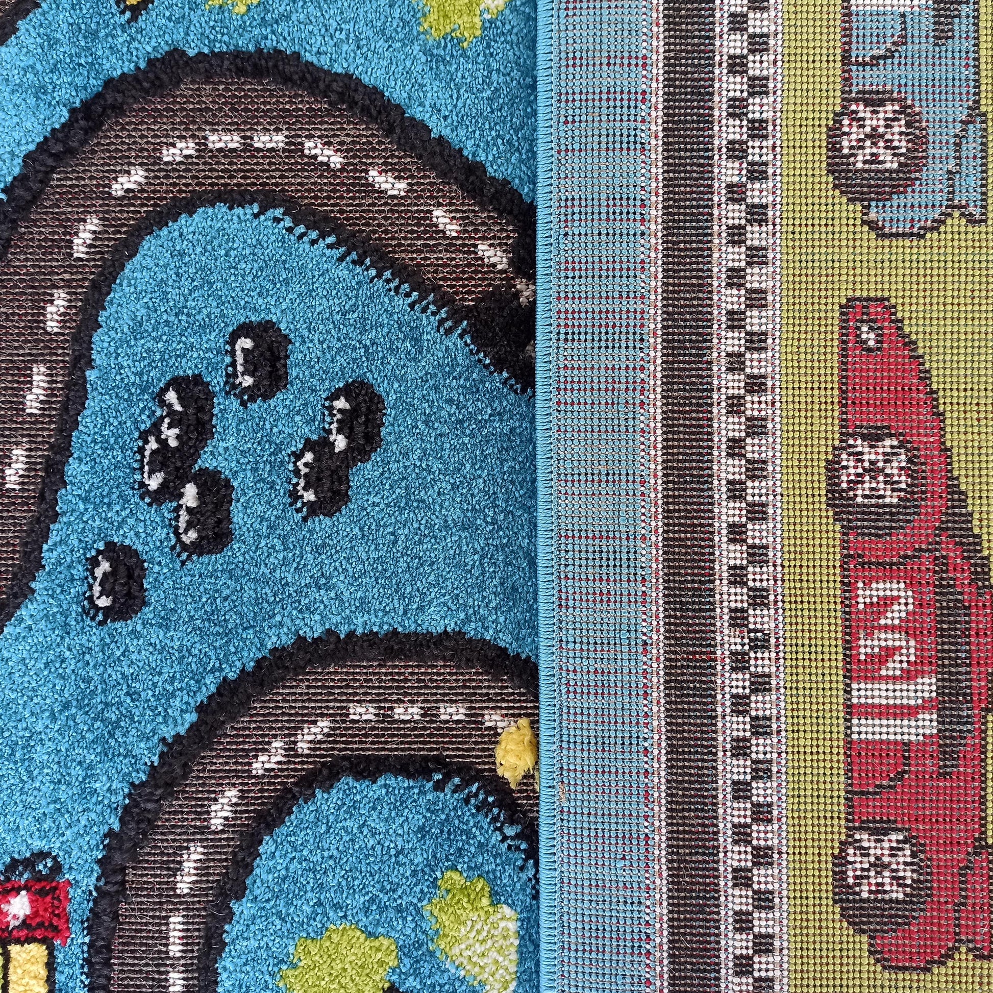 Tapis enfantin bleu à poils longs avec une route sinueuse et paysages, sa partie tissée verte montre des voitures