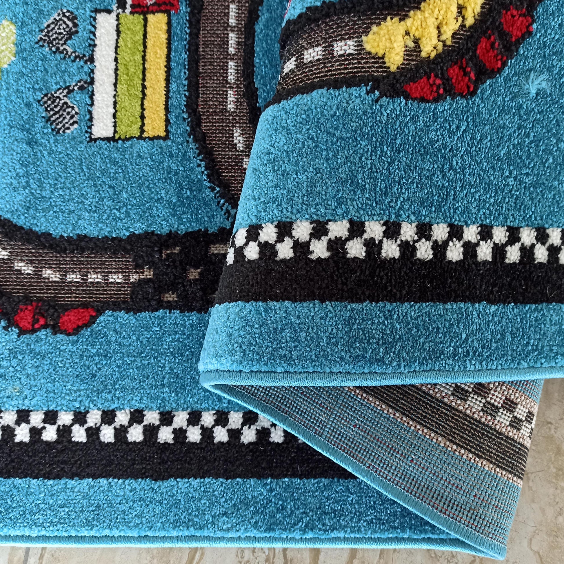 Tapis bleu turquoise doux orné de motifs de circuit, de bordures noires et d'un damier blanc et noir, avec des touches de couleur