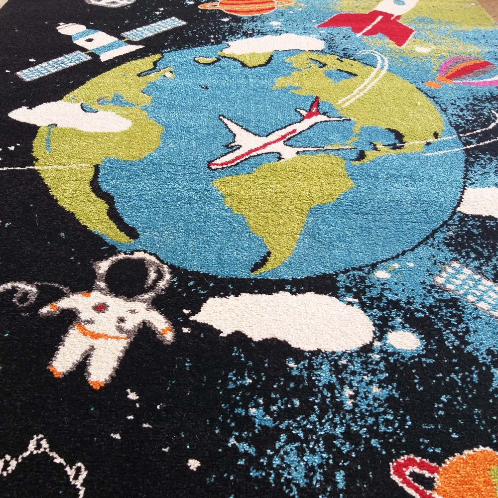 Tapis aux motifs spatiaux: Terre bleue et verte, astronaute, fusée rouge, avion blanc sur un fond noir parsemé d'étoiles