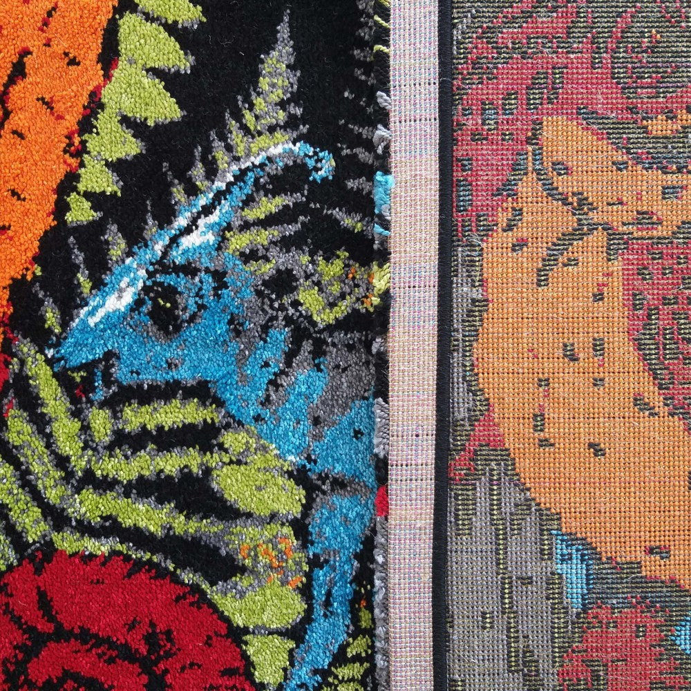 Gros plan sur un tapis aux motifs abstraits et colorés en velours dense, orange, rouge, vert, bleu et noir, avec son dos tissé apparent