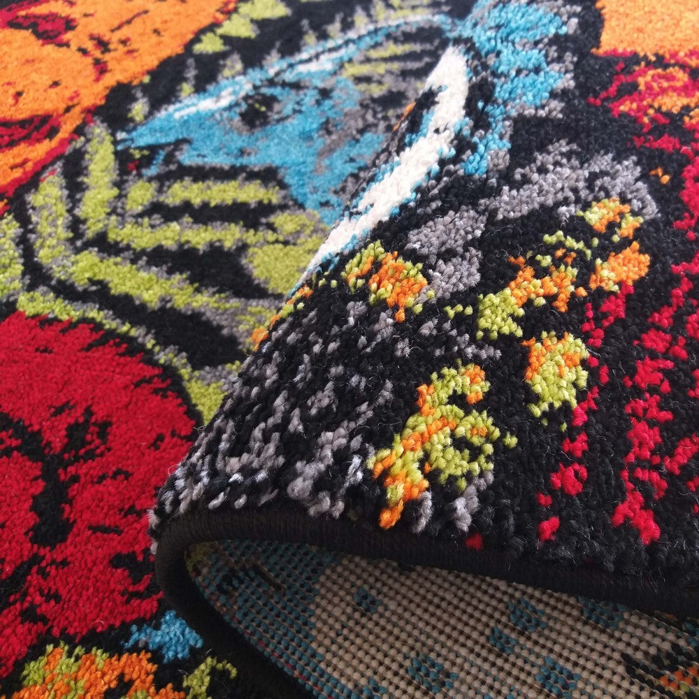Tapis aux motifs abstraits colorés : rouge, orange, vert, bleu et noir. Sa surface en poils courts est visible, ainsi que son revers