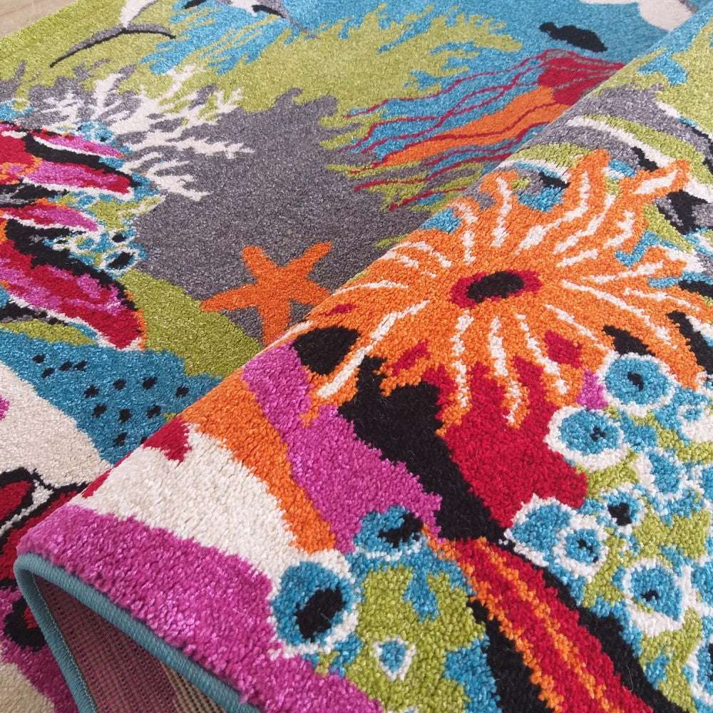 Un tapis multicolore à motifs marins avec des coraux, étoiles et créatures aquatiques dans des tons vifs d'orange, rose, bleu, vert et gris