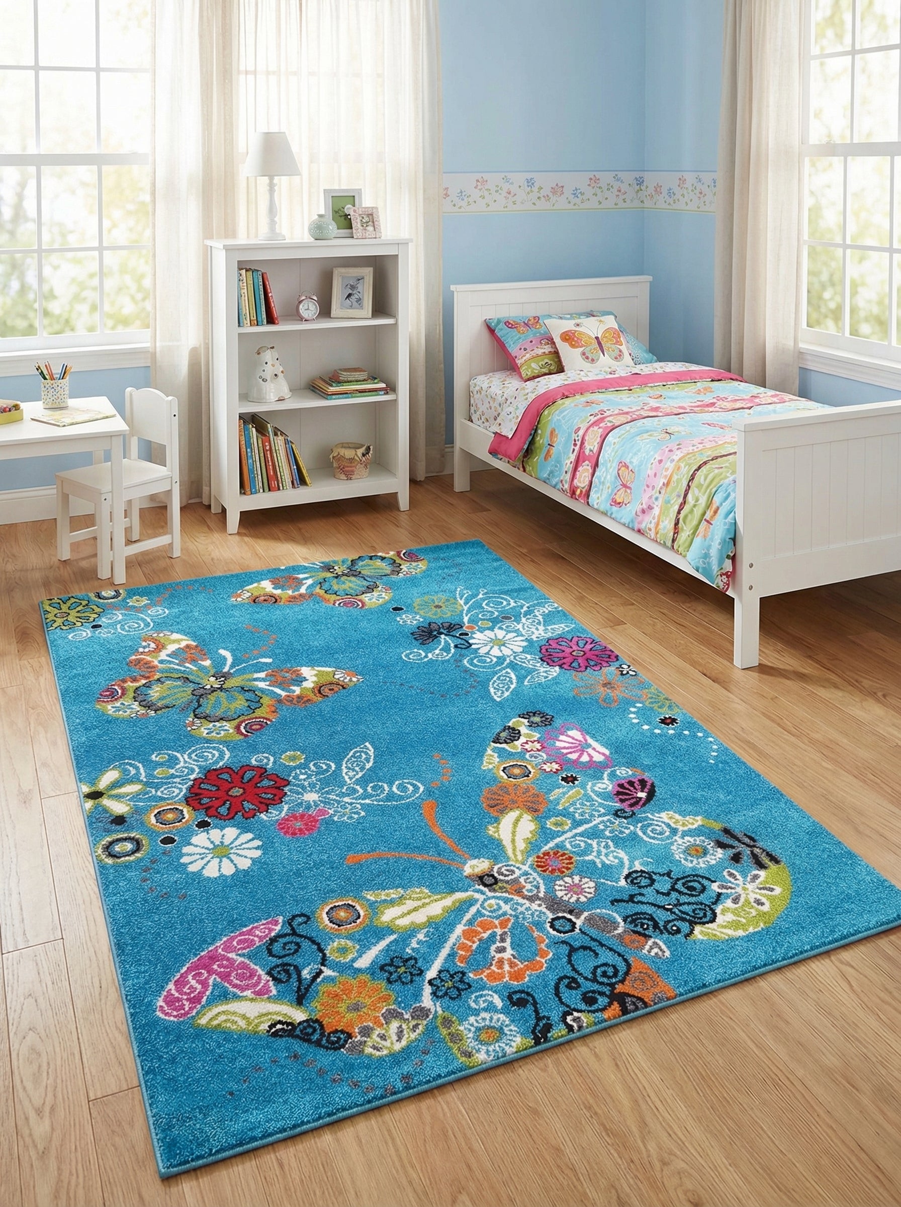 Tapis rectangulaire turquoise avec des motifs vifs de papillons et de fleurs colorées sur un sol en bois clair dans une chambre d'enfant
