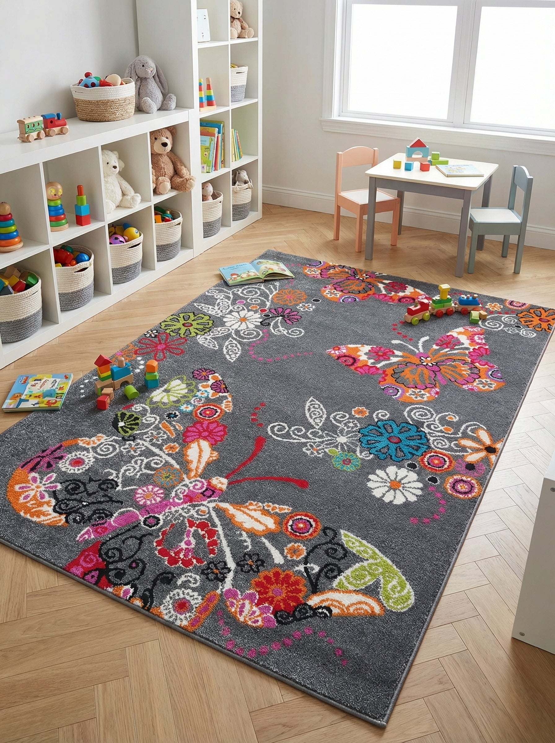 Tapis rectangulaire gris à motifs de grands papillons et de fleurs multicolores vives, sur un parquet en chevrons dans une chambre d'enfant