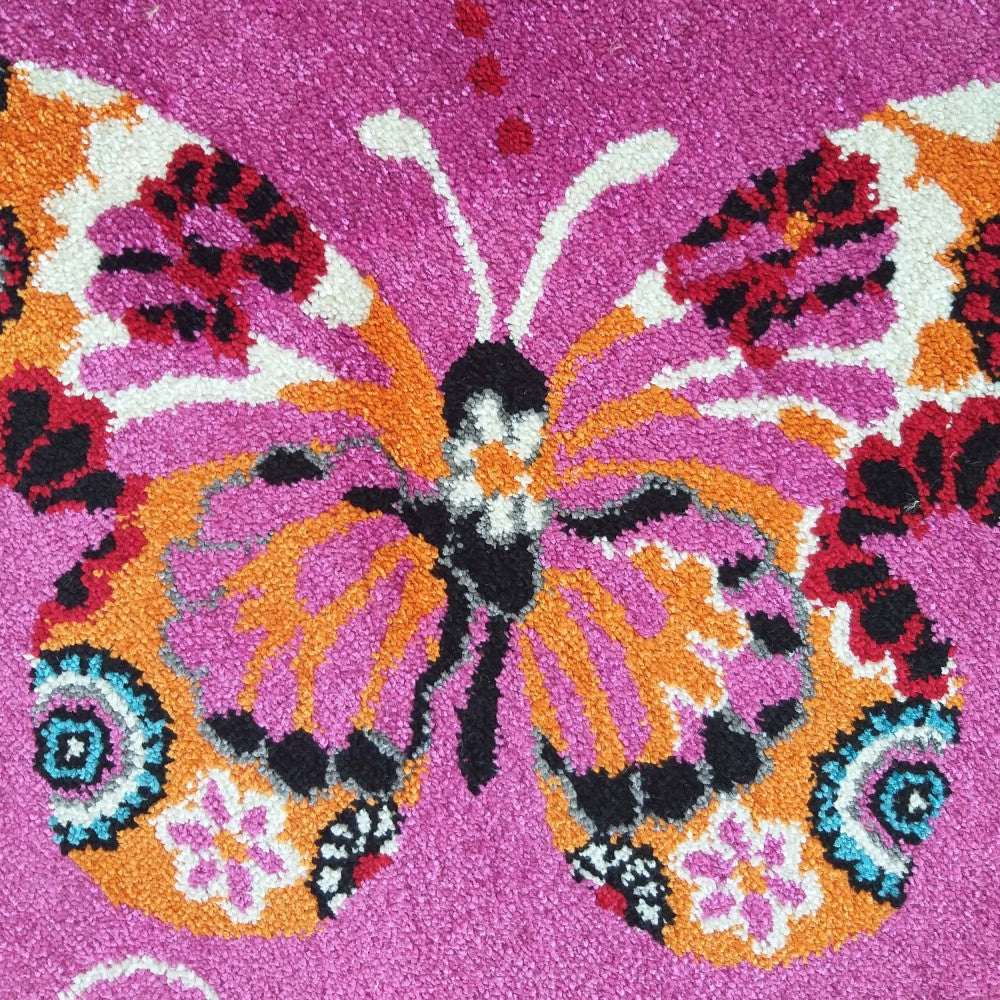 Tapis rose fuchsia avec un grand motif papillon multicolore en orange, fuchsia, blanc, noir, rouge et bleu clair