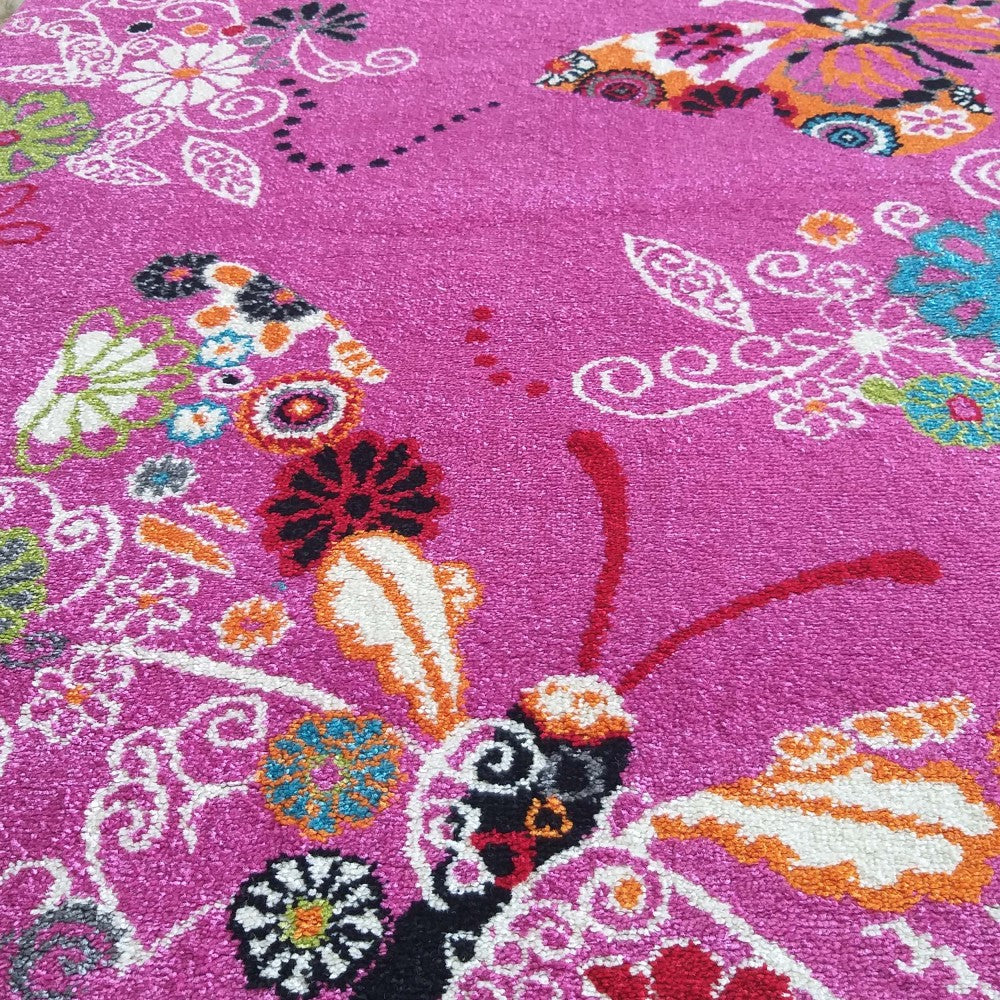 Tapis rose fuchsia à poils courts, orné de papillons, fleurs et motifs stylisés multicolores, incluant du blanc, orange, bleu, vert et noir