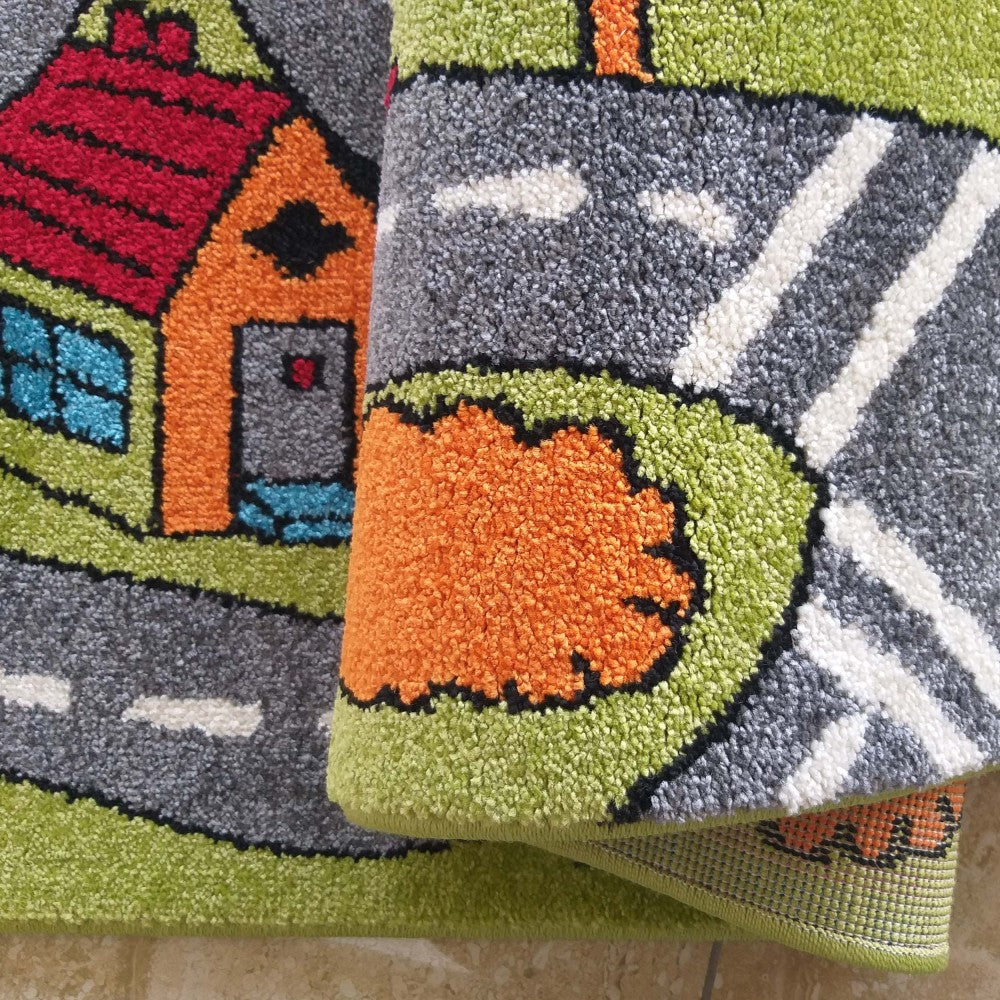 Tapis aux motifs de ville miniature : maison orange et rouge, routes grises avec marquages blancs et verdure