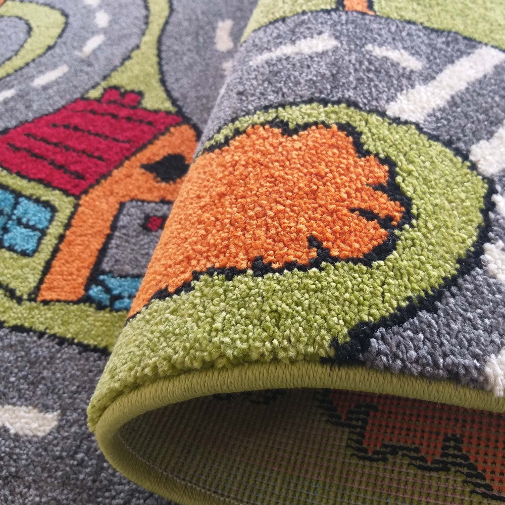 Tapis texturé à poils courts, avec un motif de route, maison et arbres aux couleurs vives vert, orange, gris, rouge et bleu