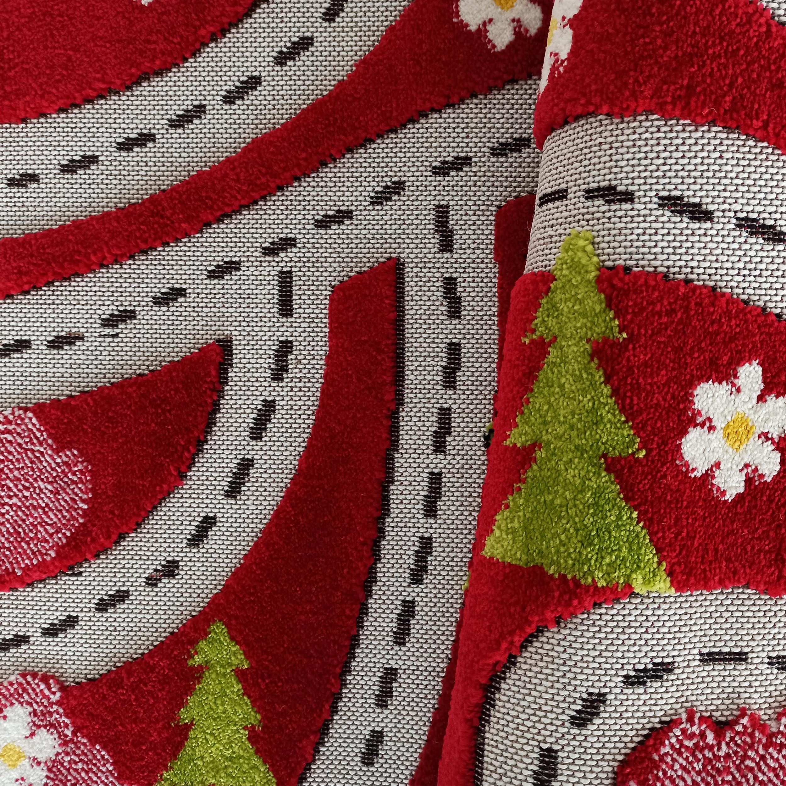 Tapis roulé à motifs de routes noires sur fond blanc, de sapins verts et de fleurs blanches à cœur jaune sur fond rouge à poils bouclés