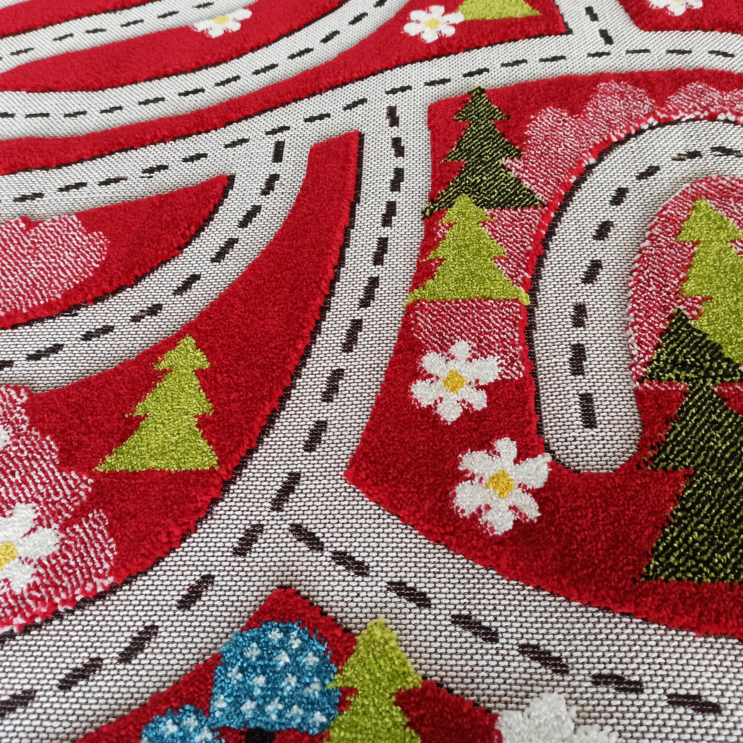 Tapis textile aux motifs de routes blanches à points noirs sur fond rouge, avec des sapins verts et des fleurs blanches