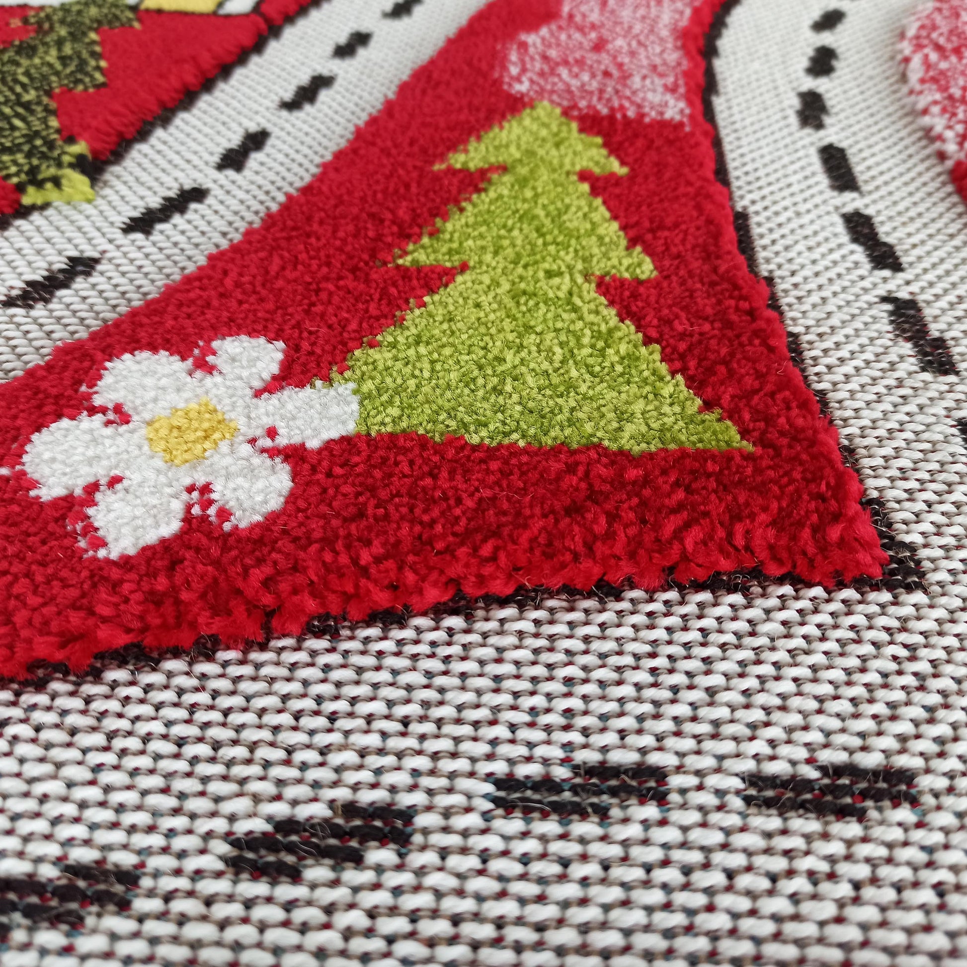 Tapis coloré avec motif d'arbre de Noël vert et fleur blanche sur fond rouge pelucheux, et tissage blanc à points sombres