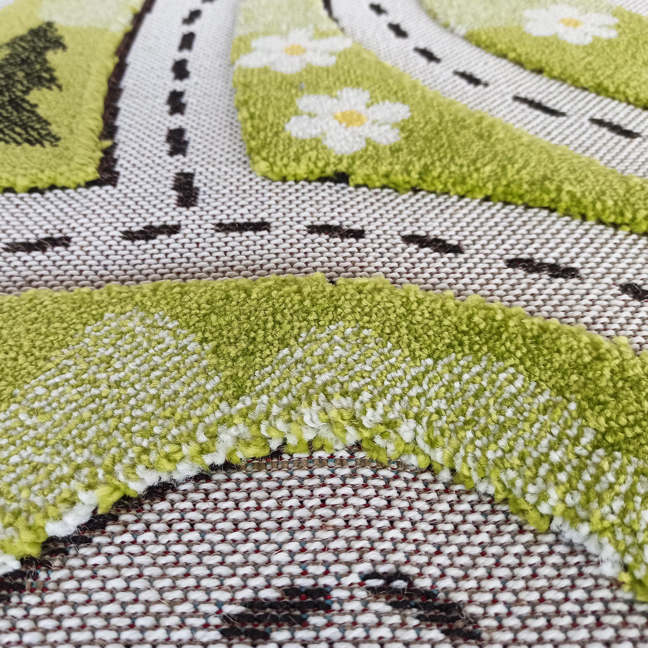Tapis texturé avec des zones vertes touffues, des petites fleurs blanches et des lignes pointillées noires sur fond tissé blanc et marron