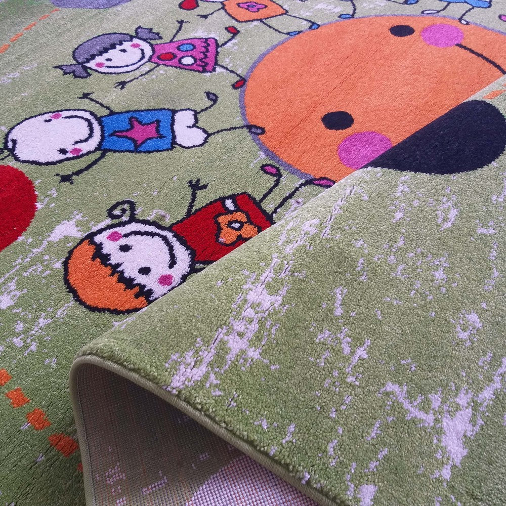 Tapis vert clair à motifs de personnages d'enfants colorés et un grand cercle orange. Une section est repliée montrant le revers texturé