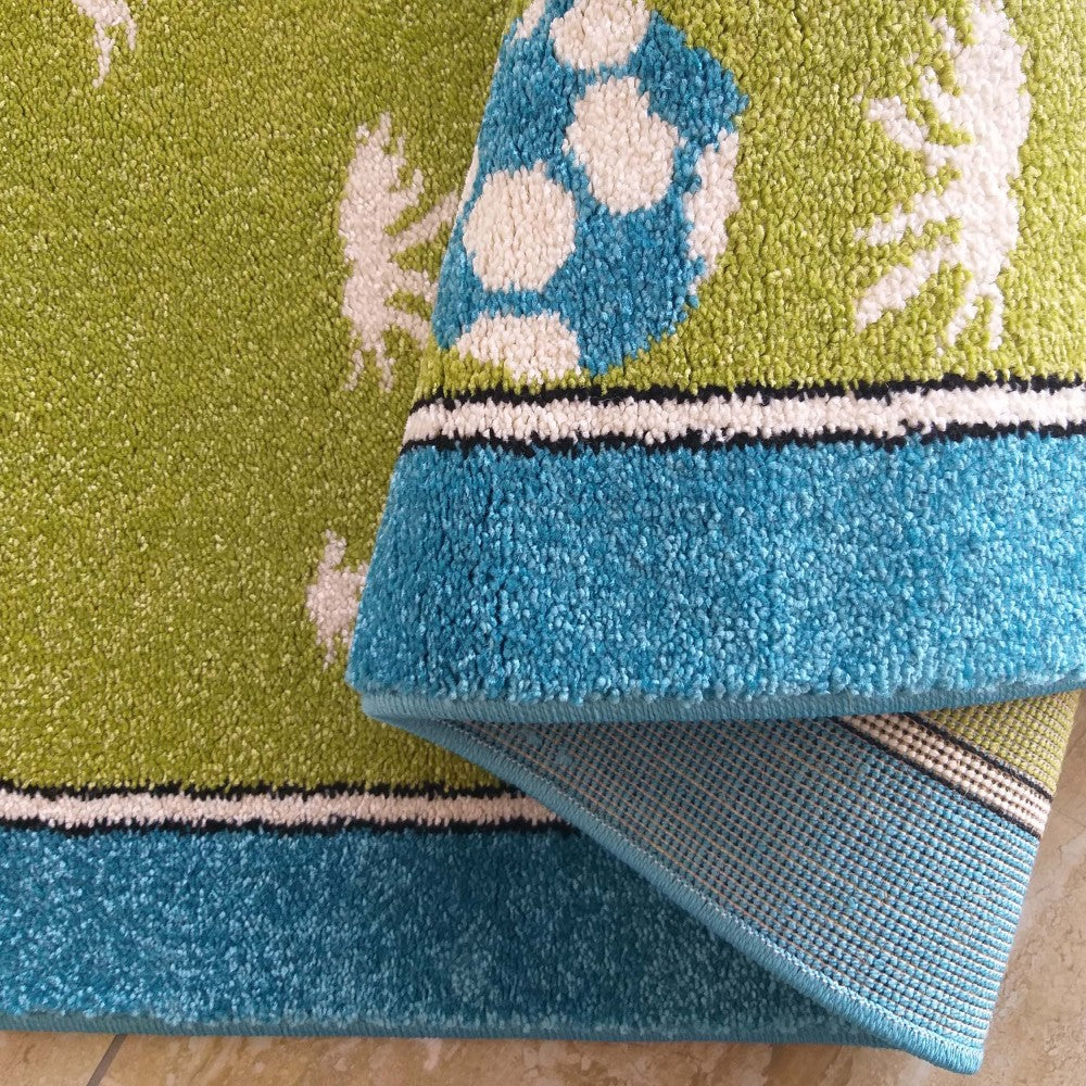 Tapis à poil long vert, bleu et blanc, avec un motif de ballon de football, des figures blanches et une bordure rayée