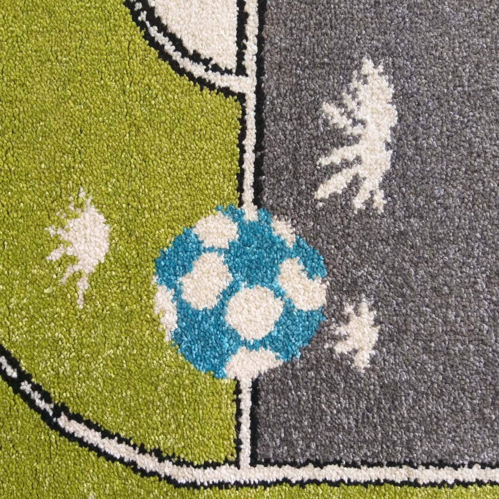 Tapis avec un motif de terrain de football, un ballon bleu et blanc sur fond vert et gris, avec des détails blancs