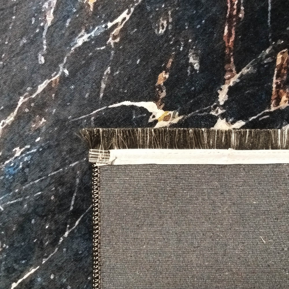 Tapis foncé à motif marbre noir, blanc et or, avec un aperçu de son envers gris tissé et de ses fibres