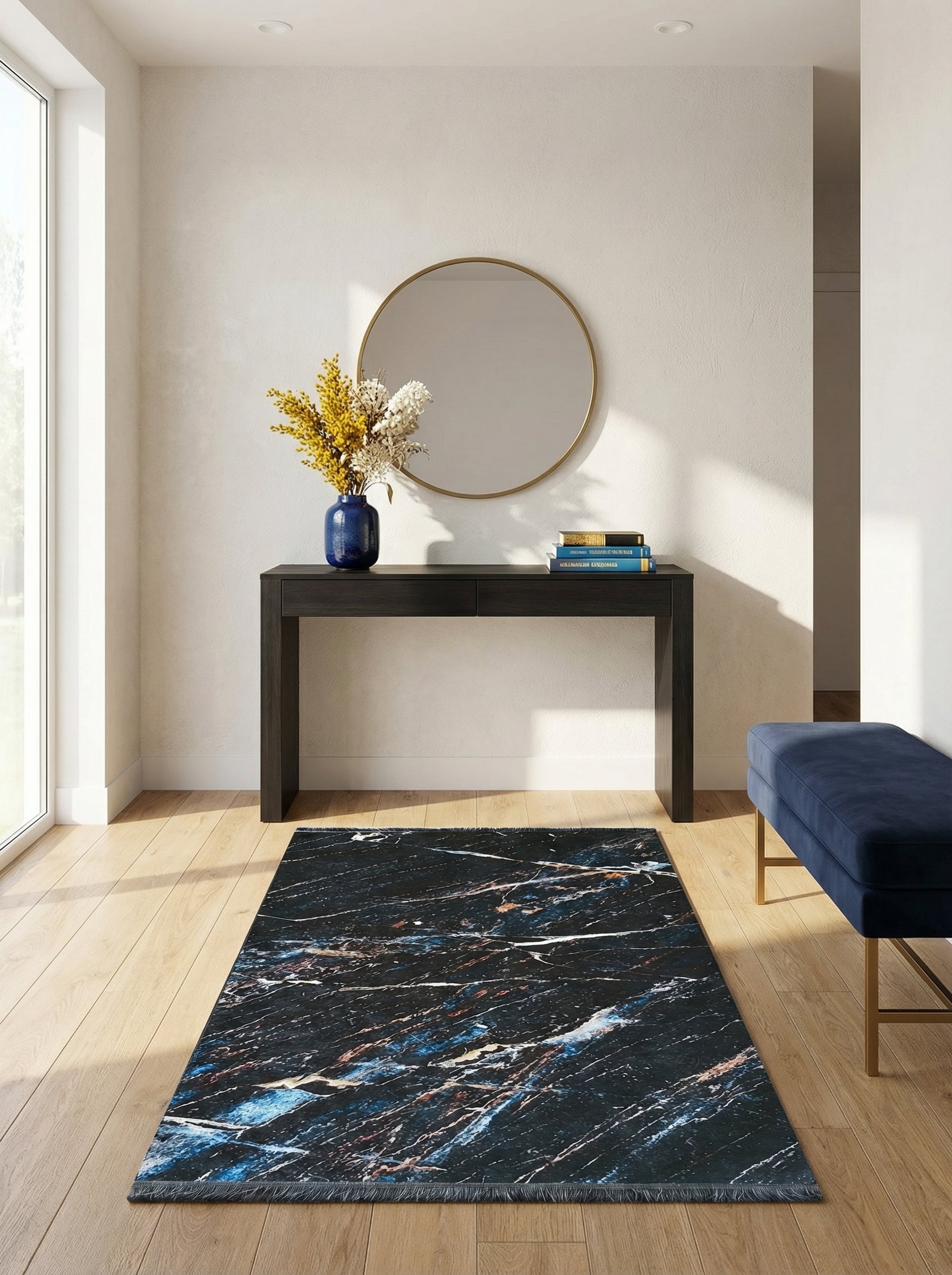 Tapis rectangulaire à motifs marbrés bleu nuit, blanc et cuivré avec franges, posé sur un parquet clair dans une entrée moderne