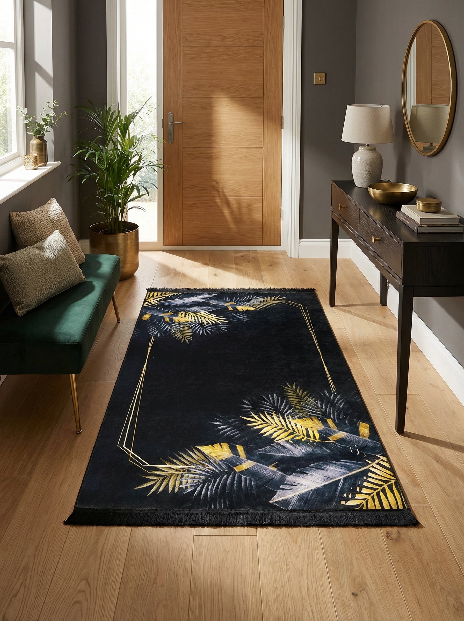 Tapis rectangulaire noir orné de feuilles tropicales dorées et grises, avec un cadre géométrique doré, posé dans une entrée moderne