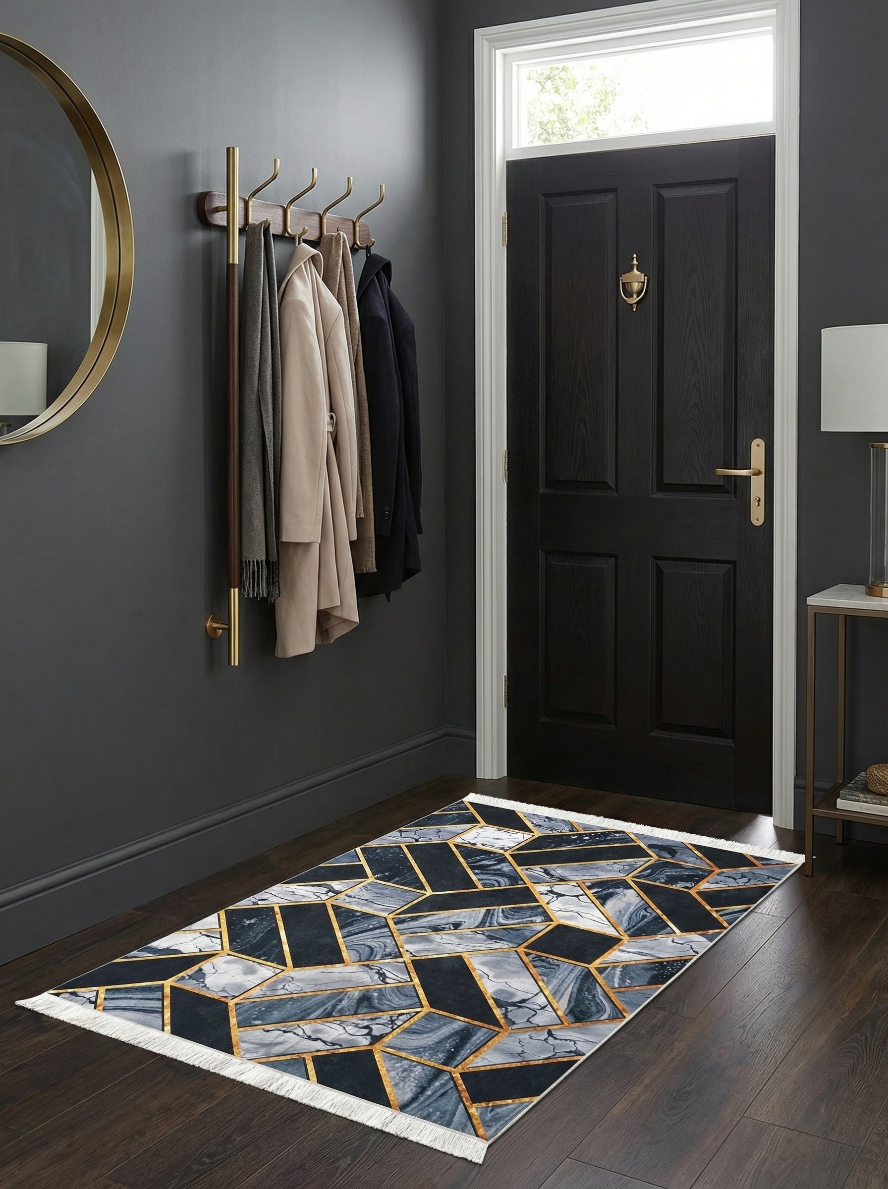 Tapis rectangulaire à motifs géométriques bleu-gris marbrés et or, avec franges, sur sol en bois foncé d'une entrée moderne