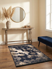 Tapis rectangulaire bleu marine avec motifs floraux et médaillons crème doré à effet vieilli, sur parquet dans une entrée