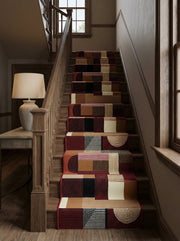 Tapis d'escalier géométrique patchwork en marron, noir, crème et bordeaux, lignes et demi-cercles, sur escalier en bois d'une entrée
