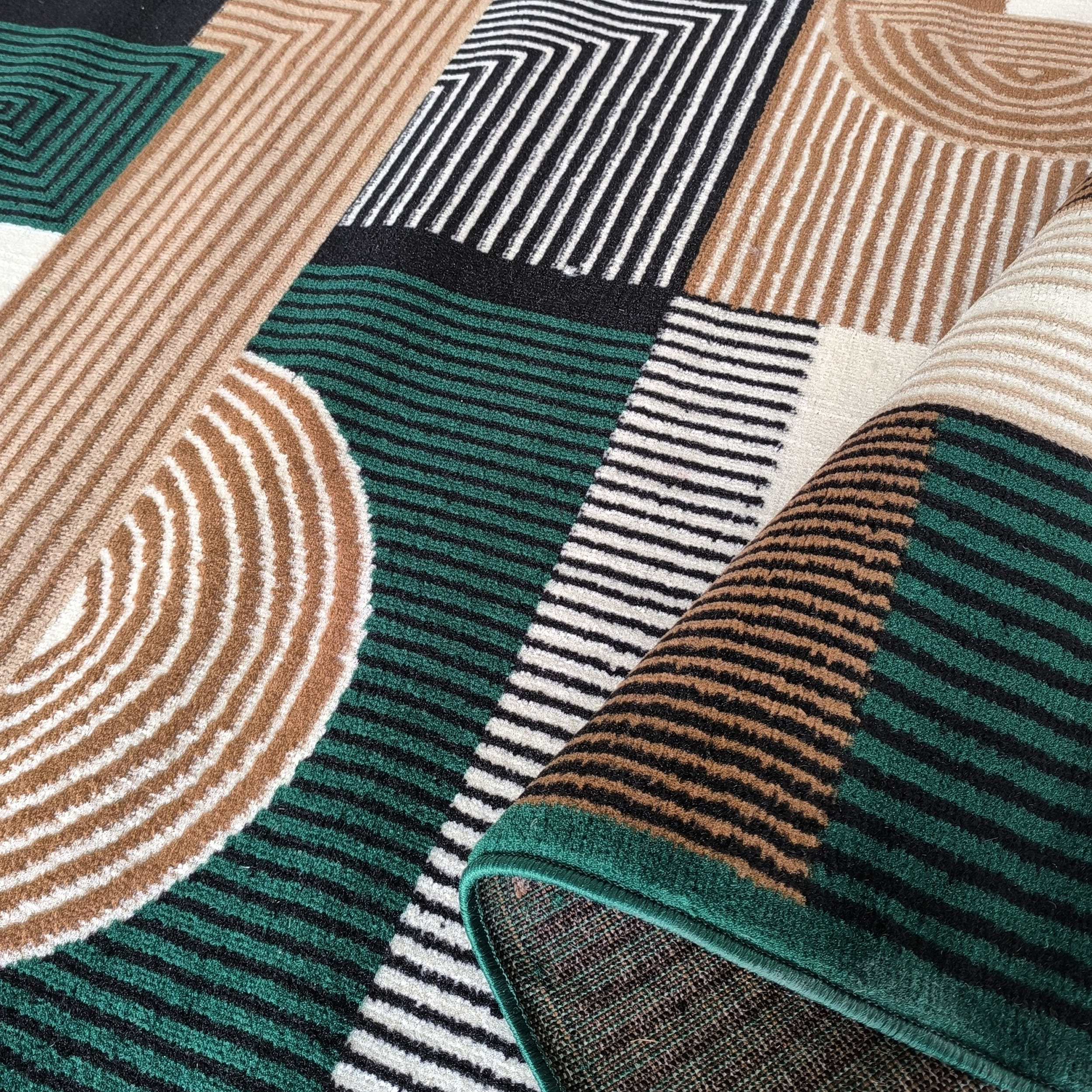 Tapis aux motifs géométriques de rayures et formes concentriques en vert, noir, marron clair et blanc, à la texture douce, partiellement roulé