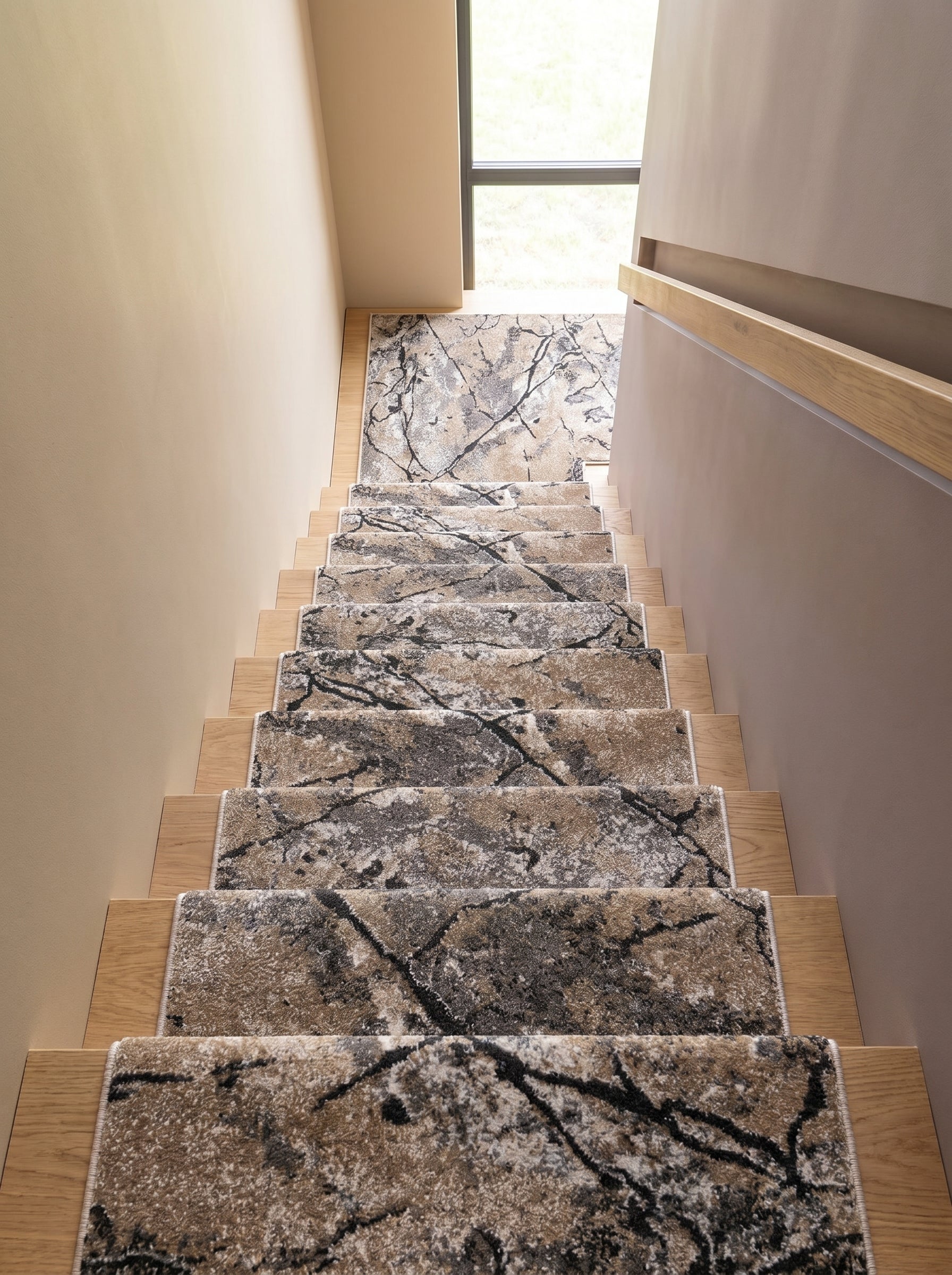 Tapis d'escalier et de palier aux motifs abstraits noirs, gris et beiges sur marches en bois clair dans une entrée moderne