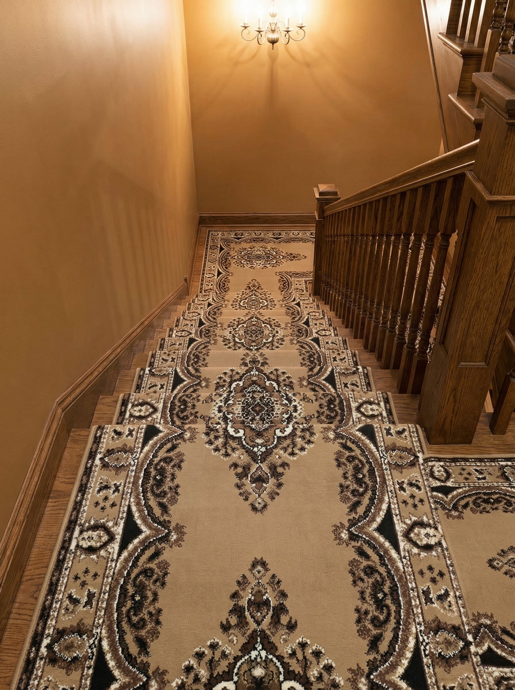 Chemin de tapis beige et marron avec motifs floraux traditionnels noirs et crème, couvrant un escalier en bois dans une entrée élégante
