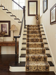 Long tapis d'escalier beige et marron à motifs orientaux, fixé sur des marches en bois sombre d'une entrée