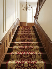 Tapis d'escalier somptueux rouge bordeaux et or, orné de riches motifs floraux baroques, sur un escalier en bois d'un hall élégant