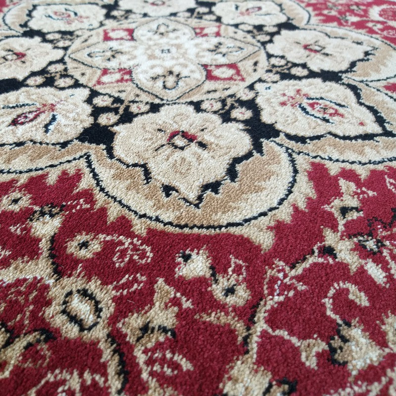 Tapis aux motifs floraux complexes rouges bordeaux, beiges et noirs avec une texture douce et veloutée