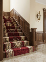 Chemin de tapis bordeaux et crème à motifs floraux baroques orne un escalier en bois élégant, dans un hall d'entrée