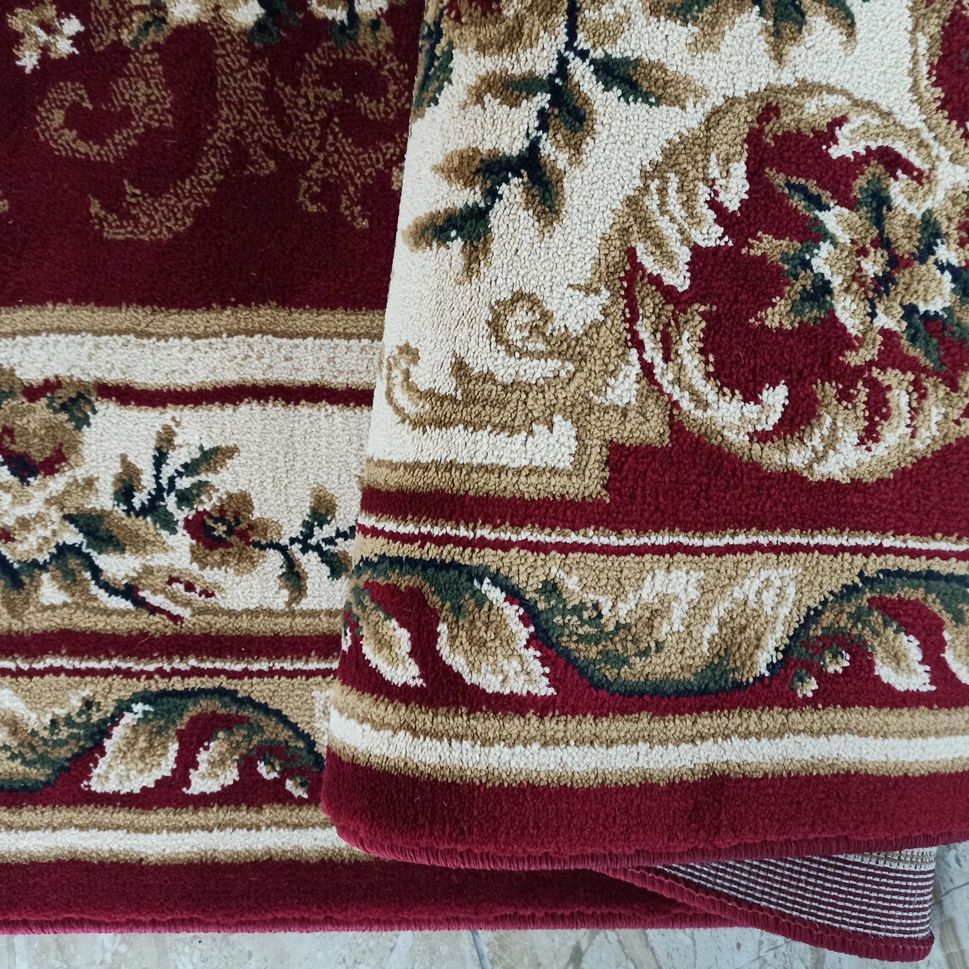 Tapis bordeaux aux motifs floraux traditionnels en crème, beige et vert, montrant sa texture épaisse et moelleuse