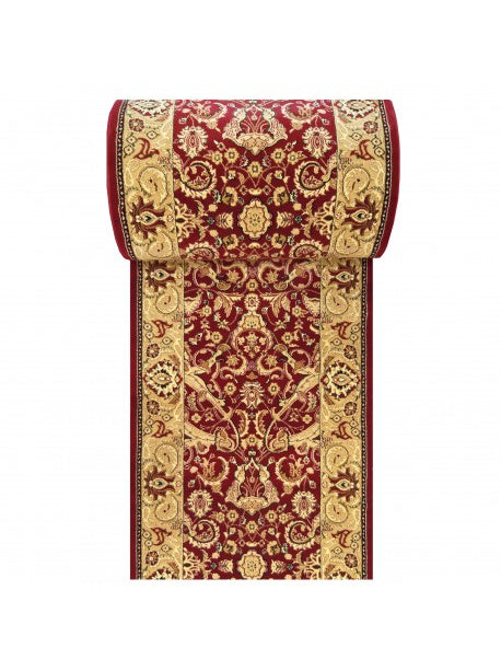 Tapis bordeaux et doré à motifs floraux et arabesques, avec une bordure ornée, partiellement roulé