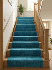 Tapis de couloir bleu canard texturé recouvrant les marches d'un escalier en bois clair, dans une entrée lumineuse