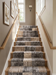 Tapis d'escalier en moquette douce à motifs abstraits de blocs gris foncés, beiges et clairs sur marches bois d'un hall