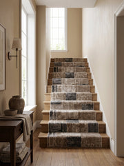 Tapis d'escalier texturé, patchwork abstrait beige, marron foncé et gris foncé sur marches en bois clair dans un hall