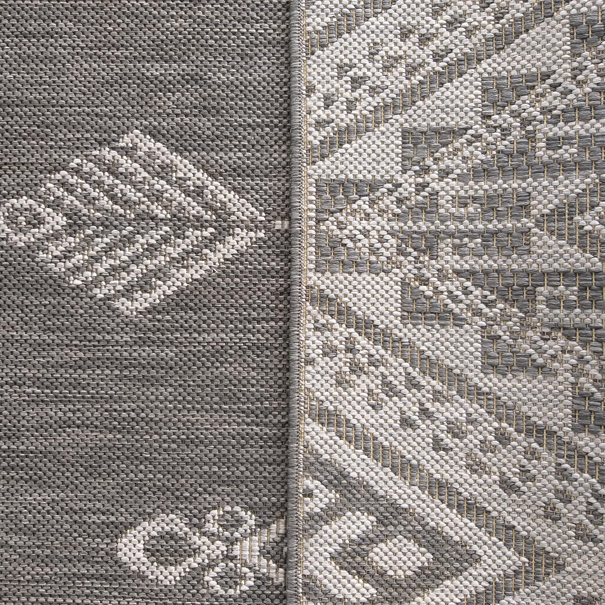 Tapis tissé à motifs géométriques en gris foncé, gris clair, blanc et beige, avec une séparation centrale