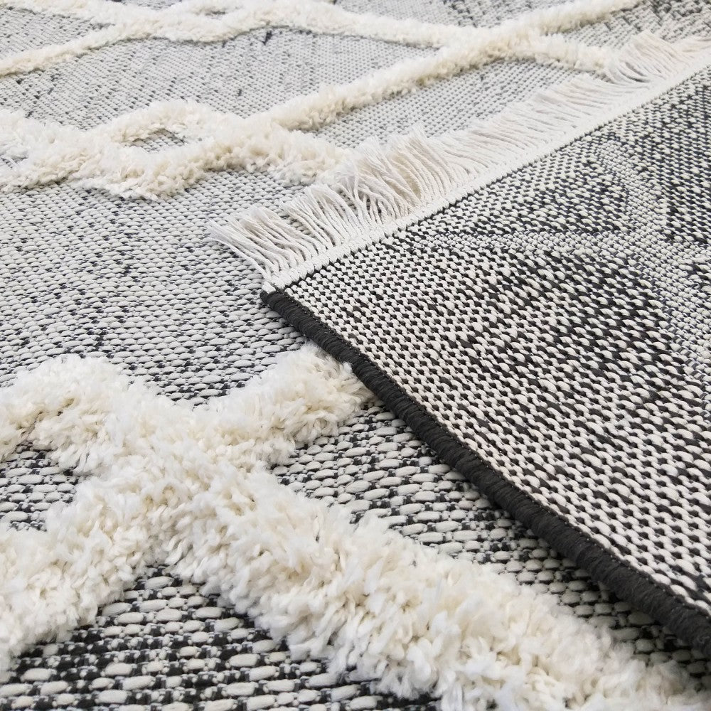 Tapis bicolore noir et blanc avec un motif en croisillons de texture duveteuse et des franges