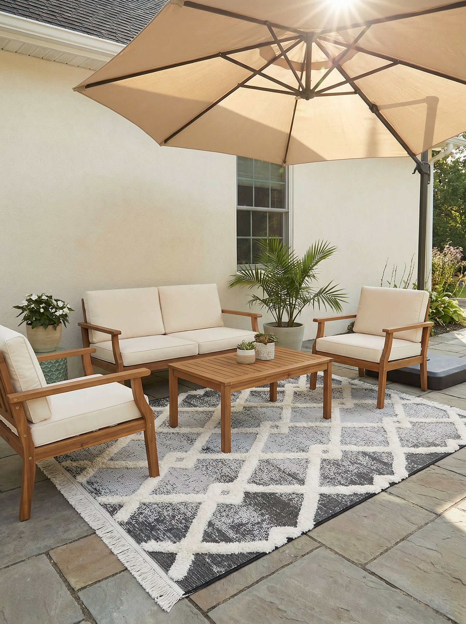 Tapis rectangulaire à motifs de losanges irréguliers en noir et blanc cassé texturé, avec franges, sur une terrasse extérieure