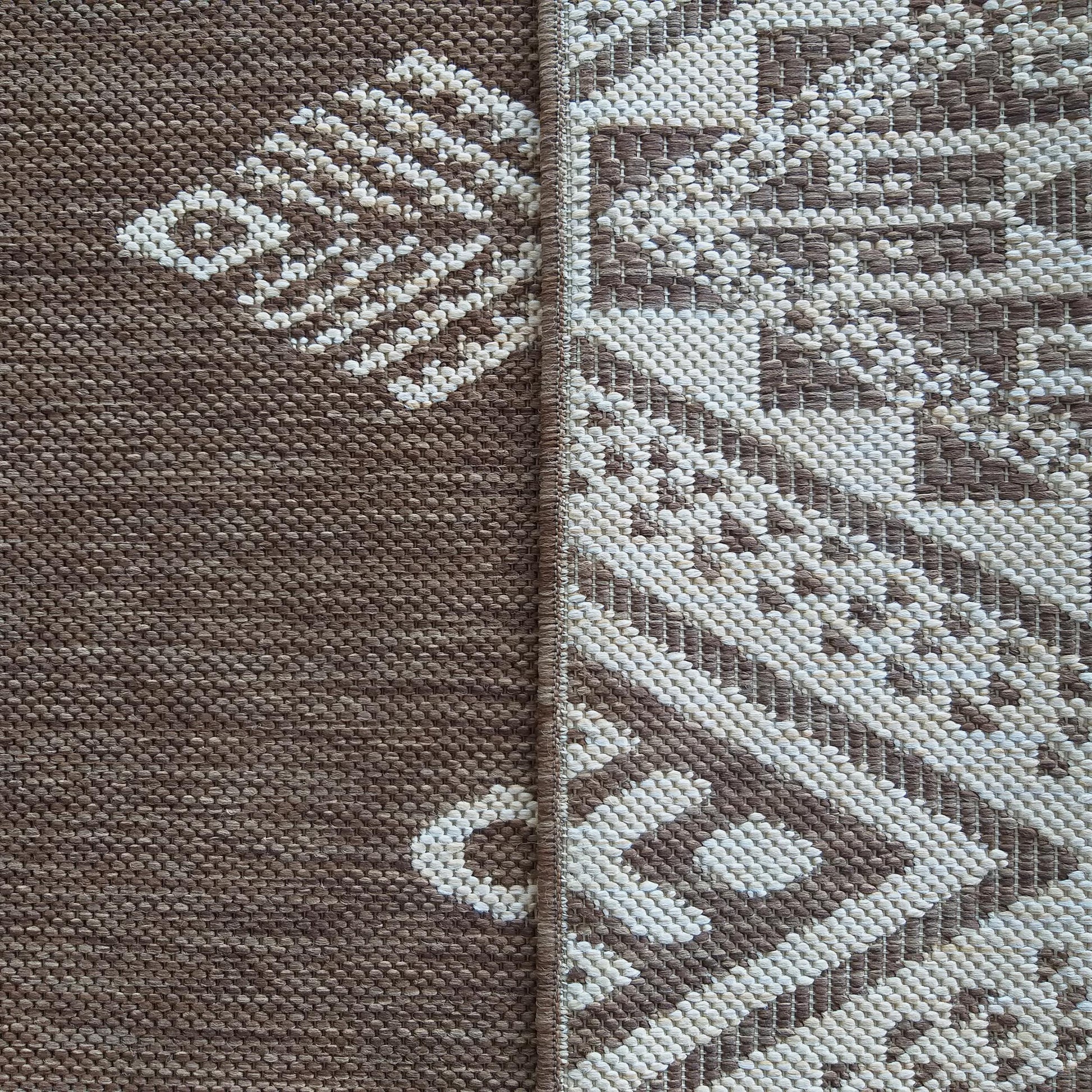 Tapis tissé marron et écru. La moitié gauche présente des motifs géométriques discrets, l'autre côté a des motifs complexes