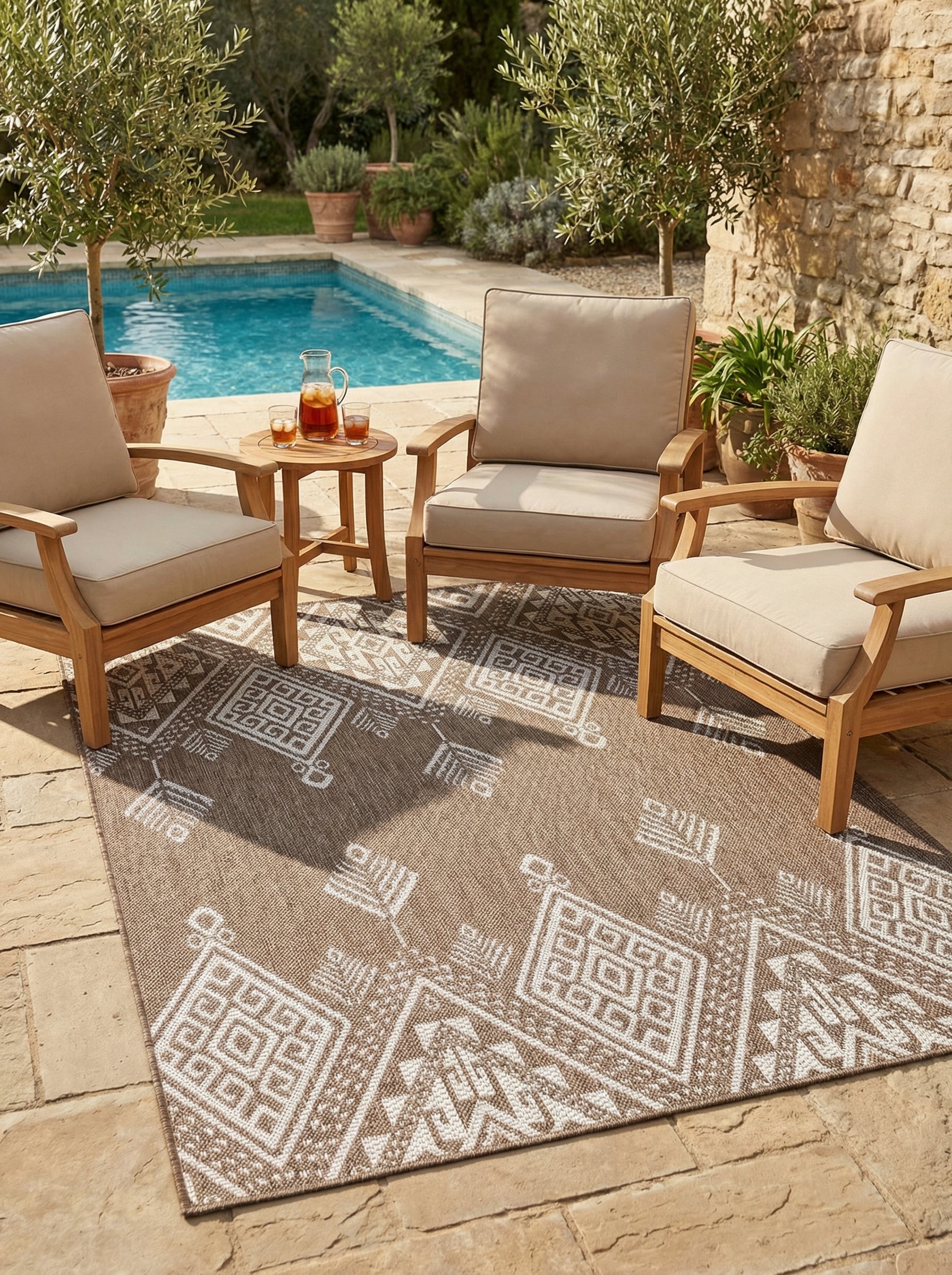 Tapis tissé rectangulaire beige avec motifs géométriques blancs, sur une terrasse près d'une piscine