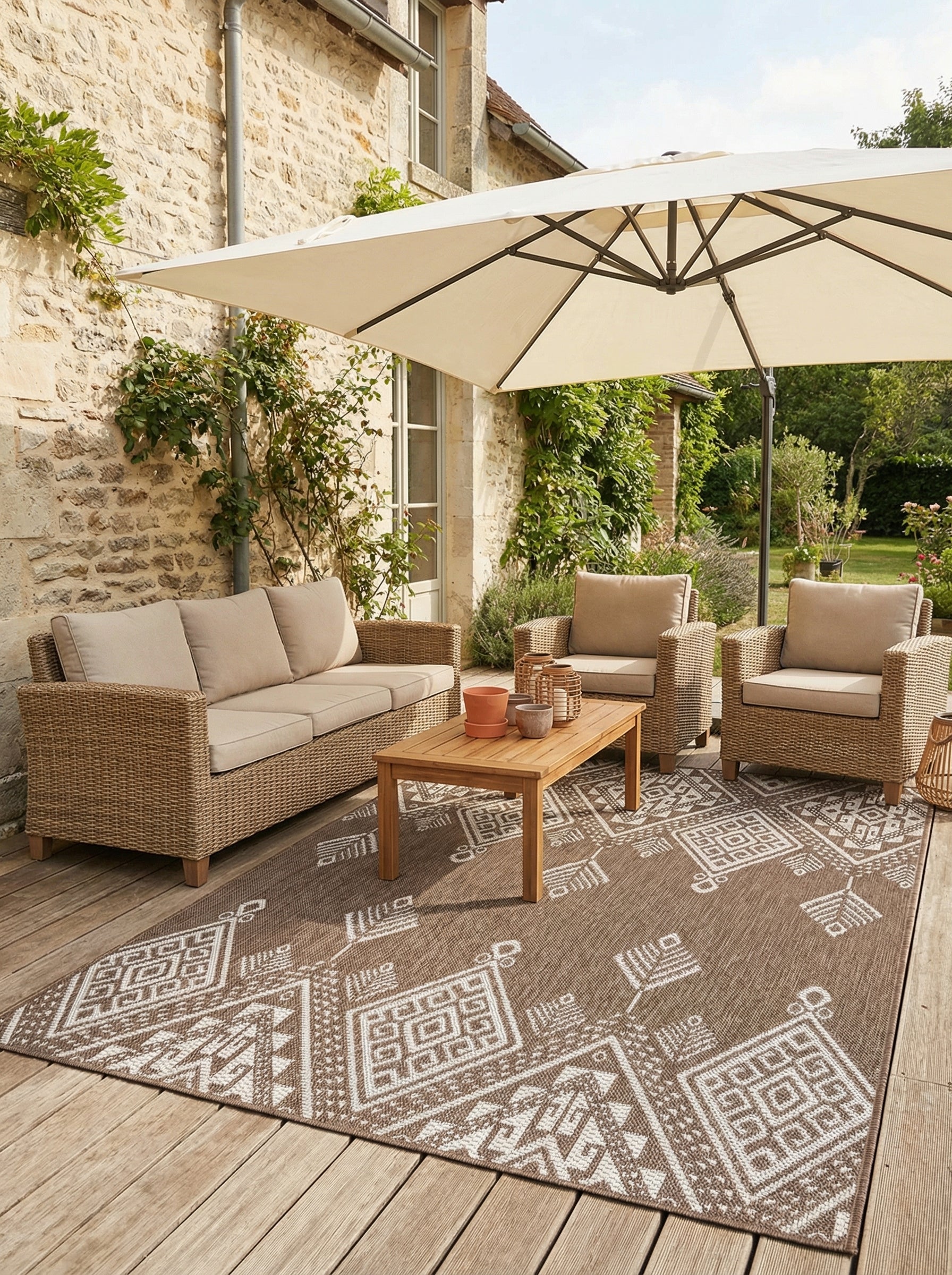 Tapis d'extérieur rectangulaire tissé marron avec motifs géométriques blancs d'inspiration ethnique sur une terrasse
