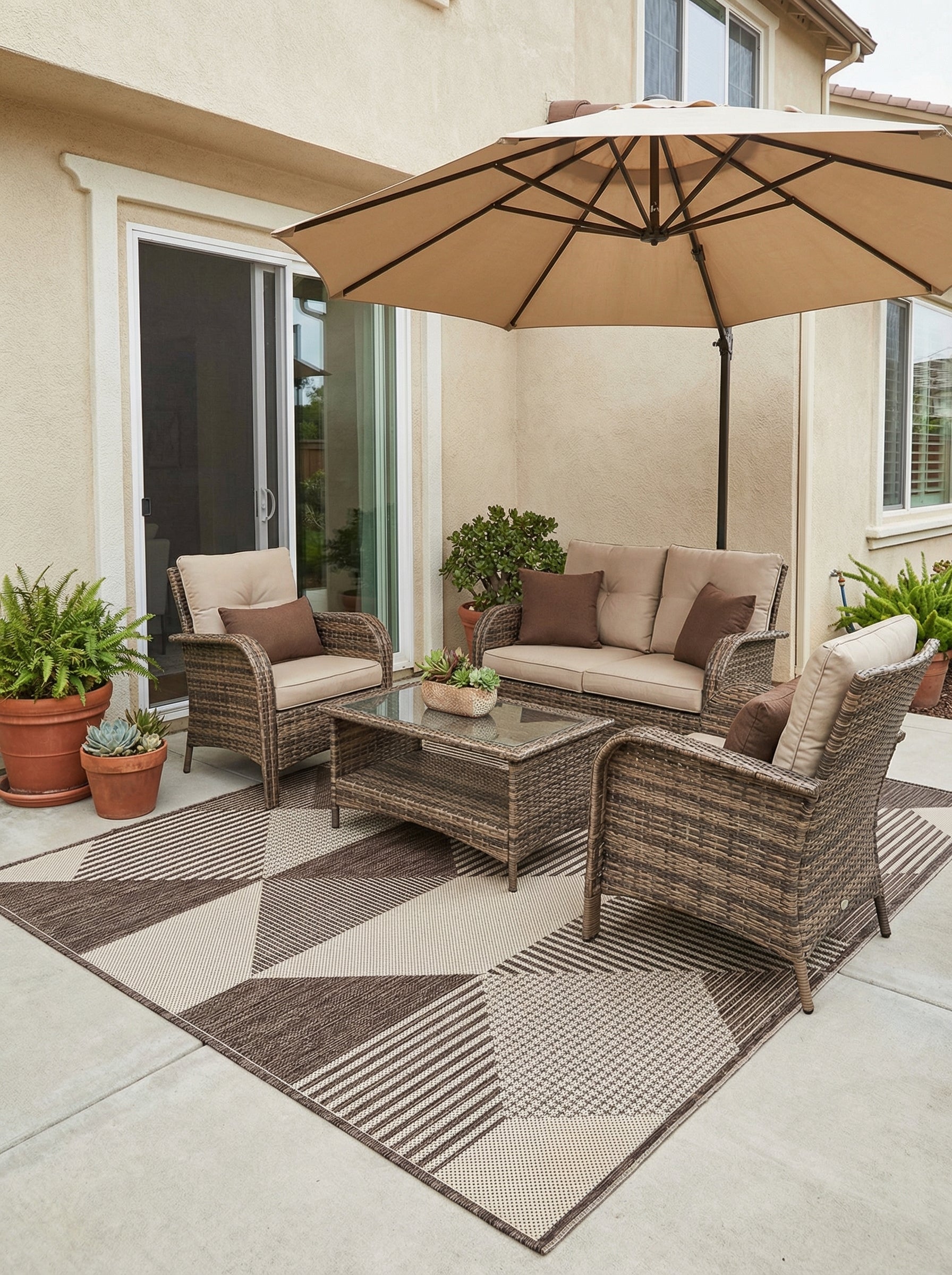 Tapis rectangulaire tissé marron et beige à motifs géométriques de triangles et rayures, posé sur une terrasse aménagée
