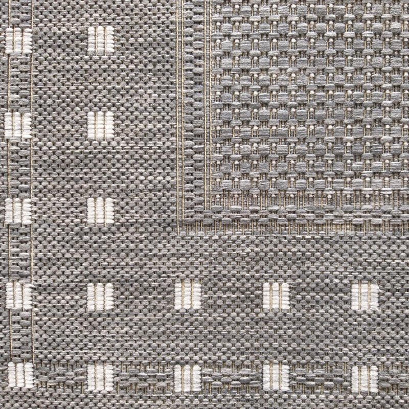 Tapis gris chiné à la texture tissée, présentant un motif de rectangles clairs et une bordure contrastante