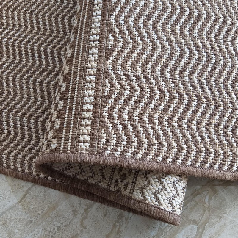 Tapis en fibres tissées marron et beige clair, avec un motif chevron et une bordure unie marron foncé
