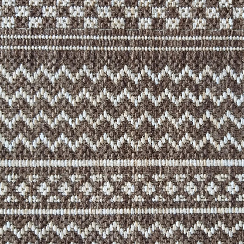 Tapis tissé marron et blanc cassé, avec des rayures horizontales, des chevrons et des motifs floraux